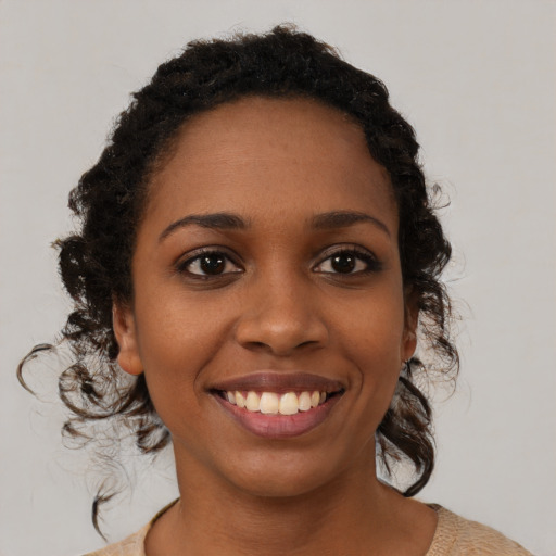 Joyful black young-adult female with medium  brown hair and brown eyes