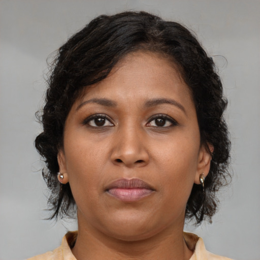 Joyful black young-adult female with medium  brown hair and brown eyes
