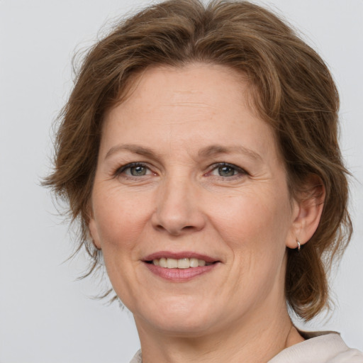 Joyful white adult female with medium  brown hair and grey eyes