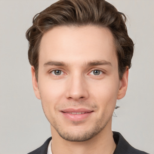 Joyful white young-adult male with short  brown hair and grey eyes