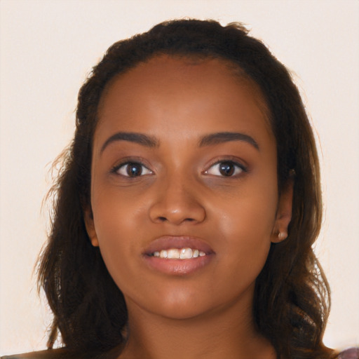 Joyful black young-adult female with long  brown hair and brown eyes