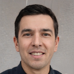 Joyful white young-adult male with short  black hair and brown eyes