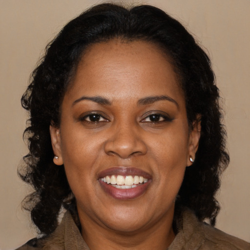 Joyful black adult female with long  brown hair and brown eyes