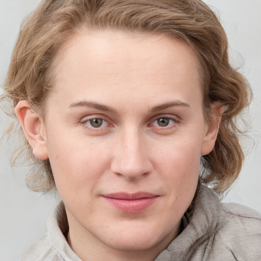 Joyful white young-adult female with medium  brown hair and blue eyes