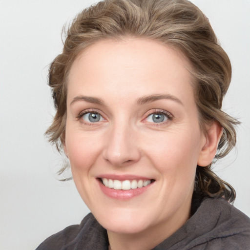 Joyful white young-adult female with medium  brown hair and blue eyes