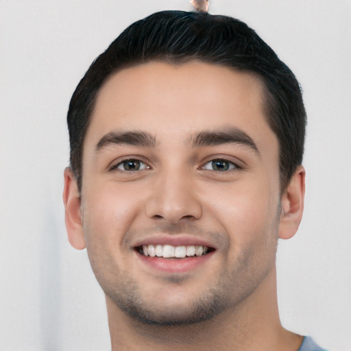 Joyful white young-adult male with short  black hair and brown eyes