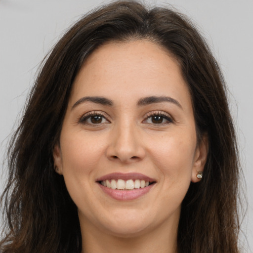 Joyful white young-adult female with long  brown hair and brown eyes