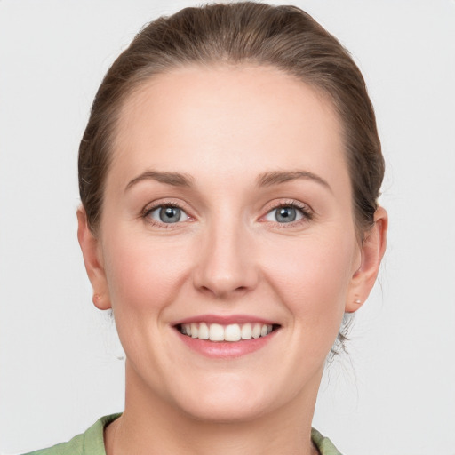 Joyful white young-adult female with medium  brown hair and green eyes