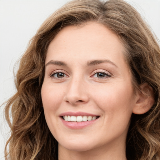 Joyful white young-adult female with long  brown hair and green eyes