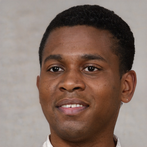 Joyful black young-adult male with short  brown hair and brown eyes