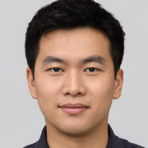 Joyful asian young-adult male with short  black hair and brown eyes