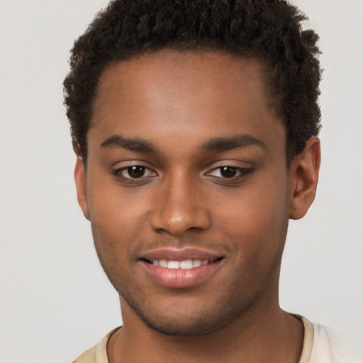 Joyful black young-adult male with short  brown hair and brown eyes