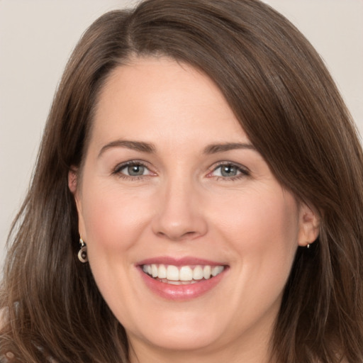 Joyful white adult female with long  brown hair and brown eyes