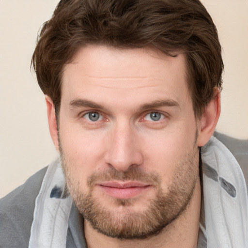 Joyful white young-adult male with short  brown hair and grey eyes