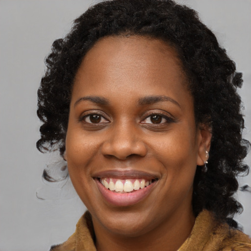 Joyful black young-adult female with long  brown hair and brown eyes