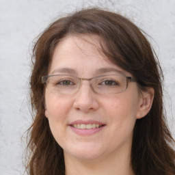 Joyful white adult female with long  brown hair and grey eyes