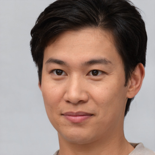 Joyful asian young-adult male with short  brown hair and brown eyes