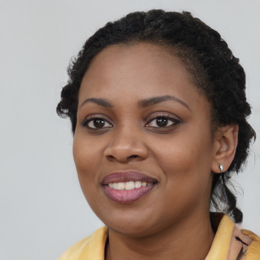 Joyful black young-adult female with long  black hair and brown eyes