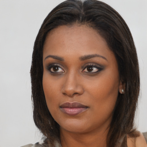 Joyful black young-adult female with long  brown hair and brown eyes