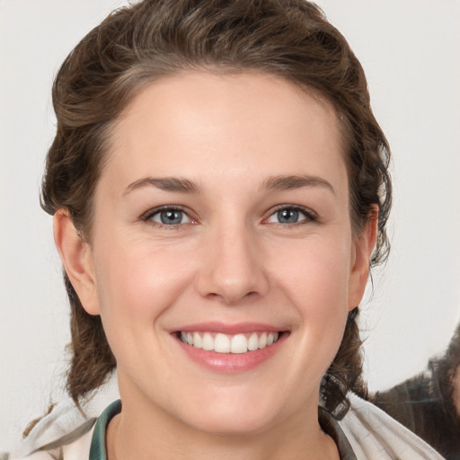 Joyful white young-adult female with medium  brown hair and grey eyes