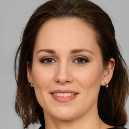 Joyful white young-adult female with long  brown hair and green eyes