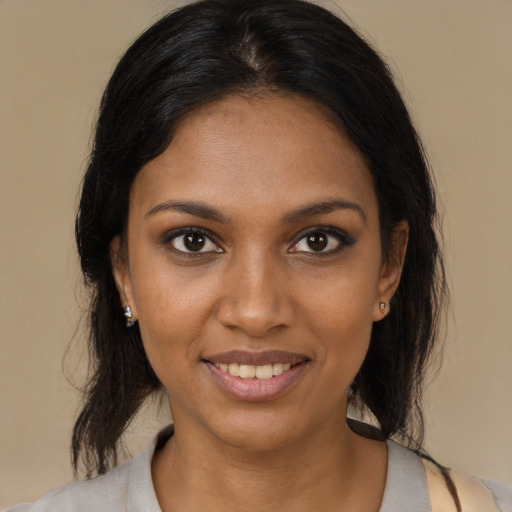 Joyful black young-adult female with medium  brown hair and brown eyes