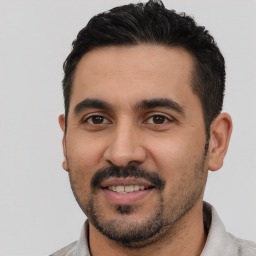 Joyful latino young-adult male with short  black hair and brown eyes