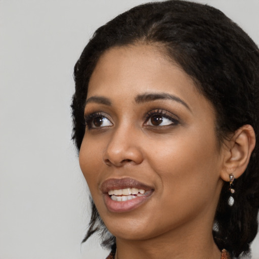 Joyful black young-adult female with medium  black hair and brown eyes
