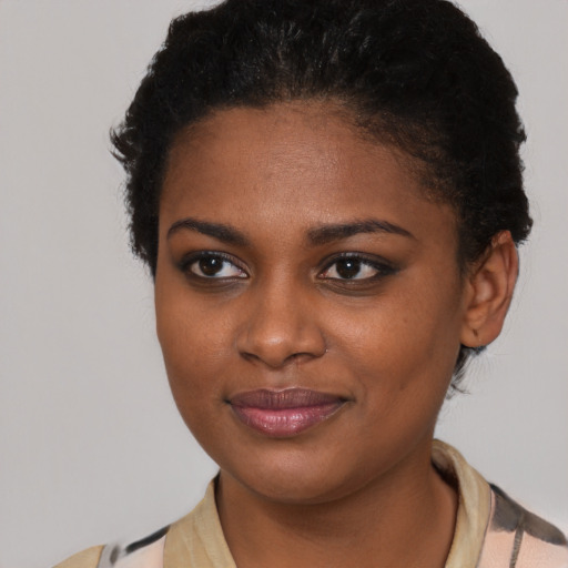 Joyful black young-adult female with short  brown hair and brown eyes