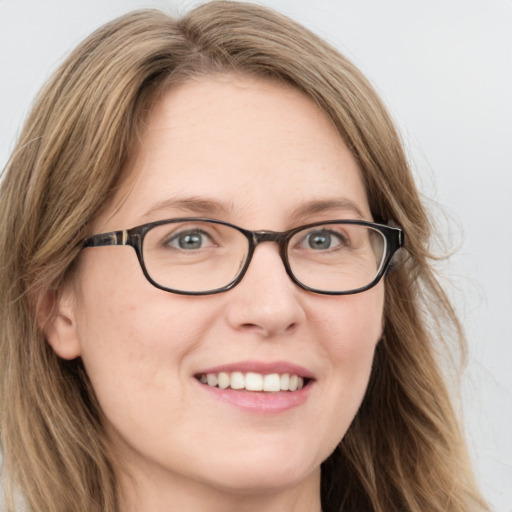 Joyful white young-adult female with long  brown hair and blue eyes