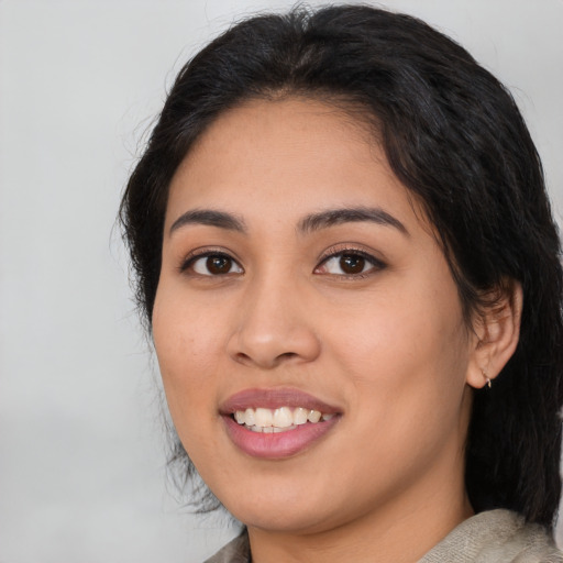 Joyful latino young-adult female with medium  brown hair and brown eyes