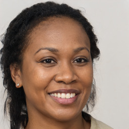 Joyful black young-adult female with long  brown hair and brown eyes