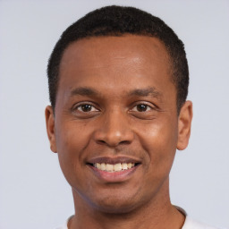 Joyful black young-adult male with short  black hair and brown eyes