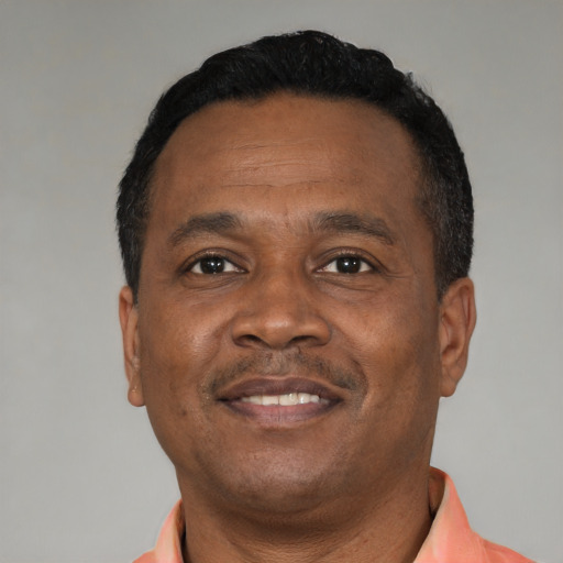 Joyful black adult male with short  black hair and brown eyes