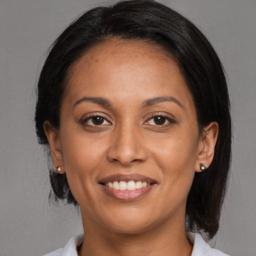Joyful black adult female with medium  brown hair and brown eyes