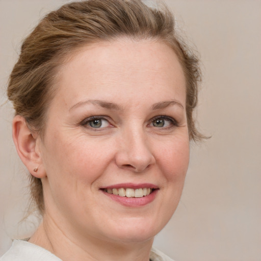 Joyful white adult female with medium  brown hair and blue eyes