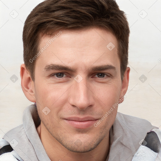 Joyful white young-adult male with short  brown hair and grey eyes