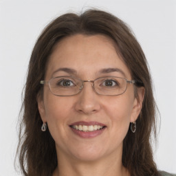 Joyful white adult female with medium  brown hair and grey eyes