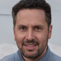 Joyful white adult male with short  brown hair and brown eyes