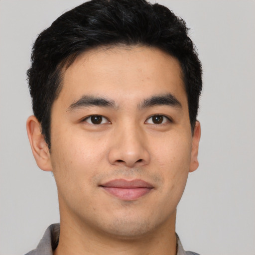 Joyful asian young-adult male with short  black hair and brown eyes