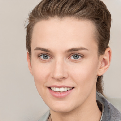 Joyful white young-adult female with short  brown hair and grey eyes