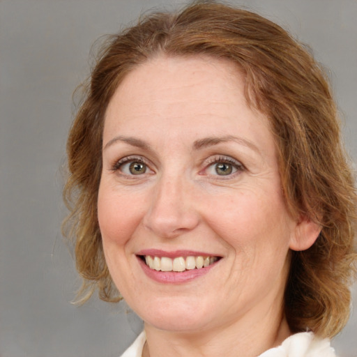 Joyful white adult female with medium  brown hair and blue eyes
