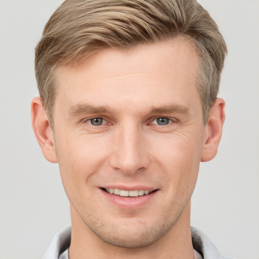 Joyful white young-adult male with short  brown hair and grey eyes