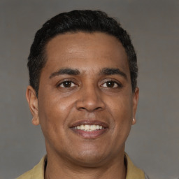 Joyful latino young-adult male with short  brown hair and brown eyes