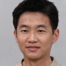 Joyful asian young-adult male with short  brown hair and brown eyes