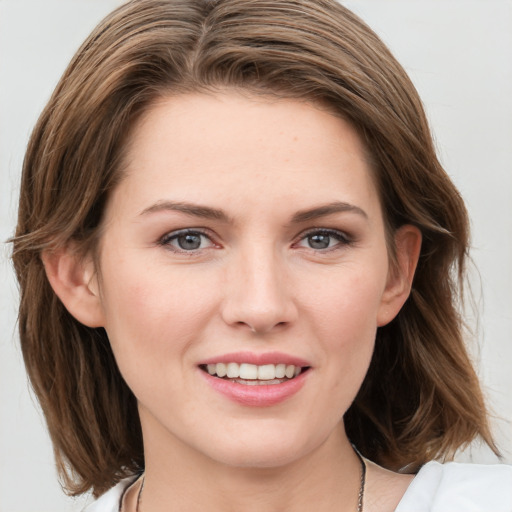 Joyful white young-adult female with medium  brown hair and blue eyes