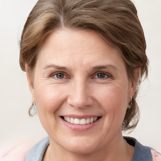 Joyful white adult female with medium  brown hair and grey eyes