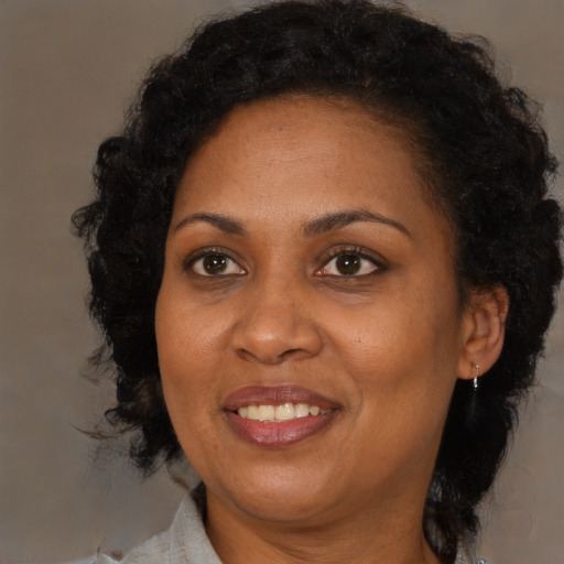 Joyful black adult female with medium  brown hair and brown eyes
