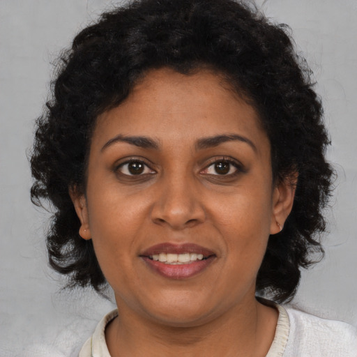Joyful black young-adult female with medium  brown hair and brown eyes