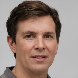 Joyful white adult male with short  brown hair and grey eyes